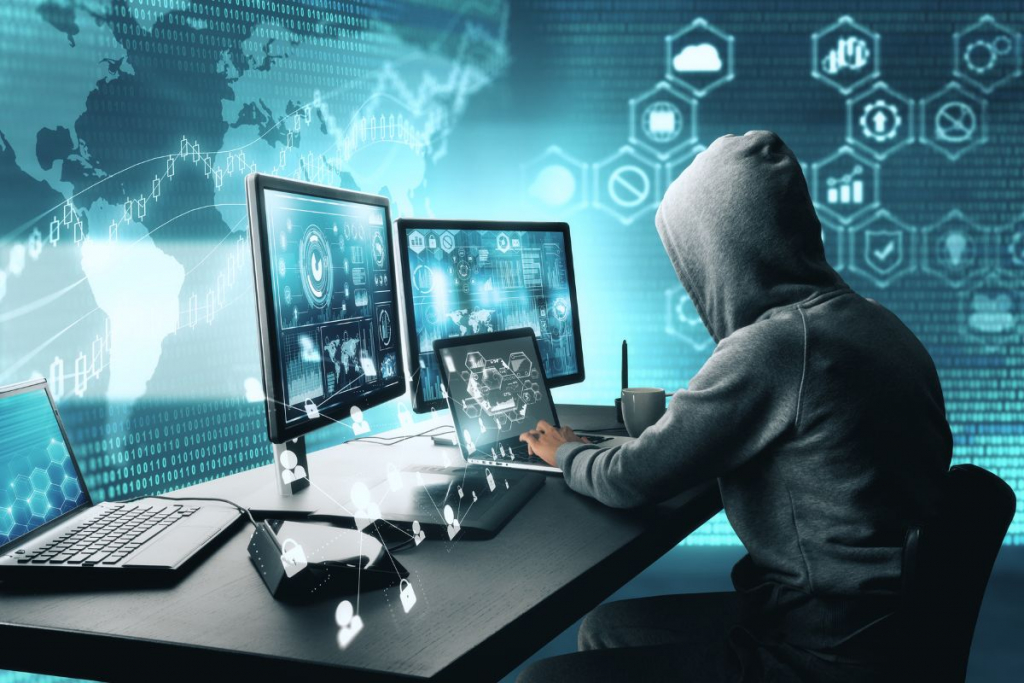 hacker di depan dua komputer